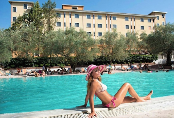 Zona de piscina con un edificio al fondo.