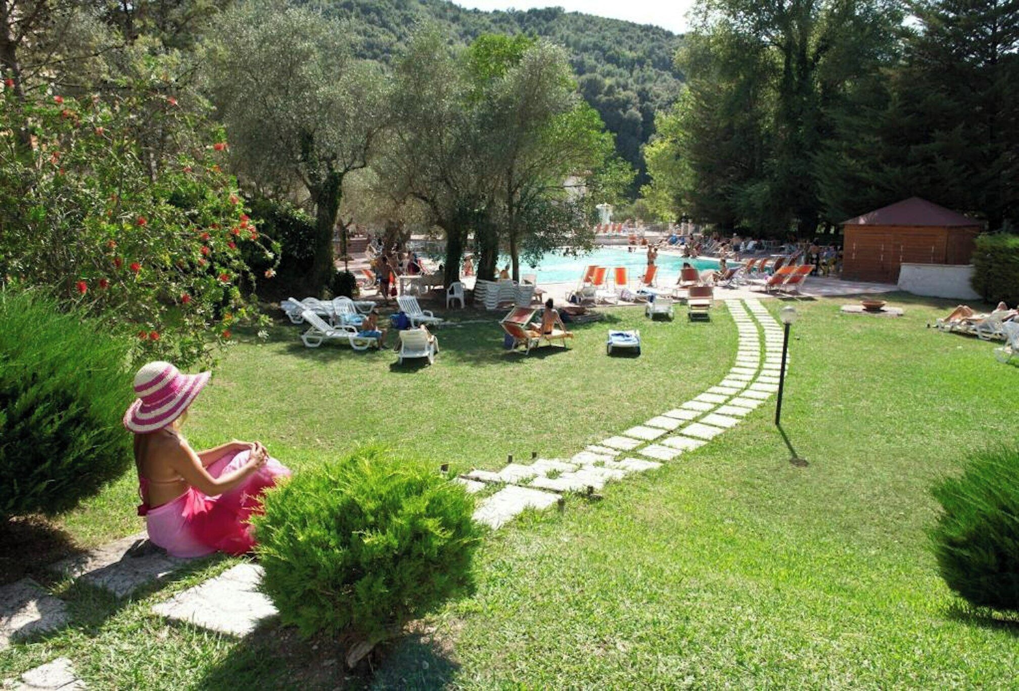 Ein Poolbereich mit Liegestühlen und einem freien Zugang zum Wasser.