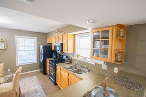 A kitchen with wooden cabinets, a refrigerator, a stove, and a sink. - • Bressingham Place • Prime Location • Pool (Bloomington)