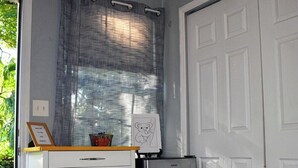 A kitchen with a white cabinet, a stainless steel refrigerator, and a window with a curtain. - THE JAX HIDEOUT 
DT studio w/shaded patio (Jacksonville)