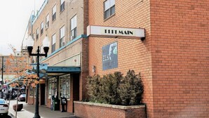 A brick building with a sign reading '111 Main' and a banner advertising 'The Elk Apartments.' - The Historic George Hotel (Klamath Falls)