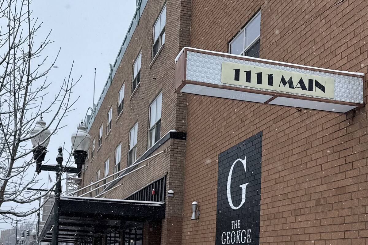 A brick building with a sign reading '111 Main' and a large sign for 'The George.'