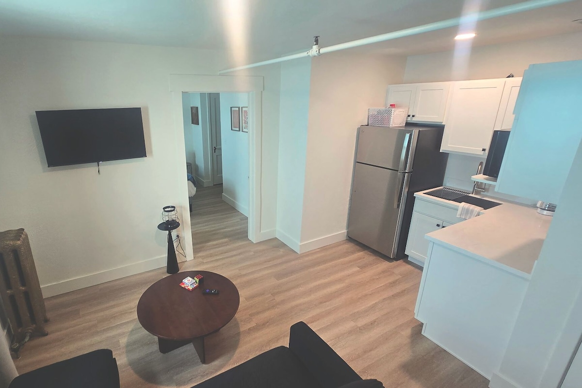 Un appartement moderne comprenant une cuisine, un coin repas et un salon.