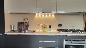 A modern kitchen with a stainless steel sink, a built-in stove, and a dishwasher.