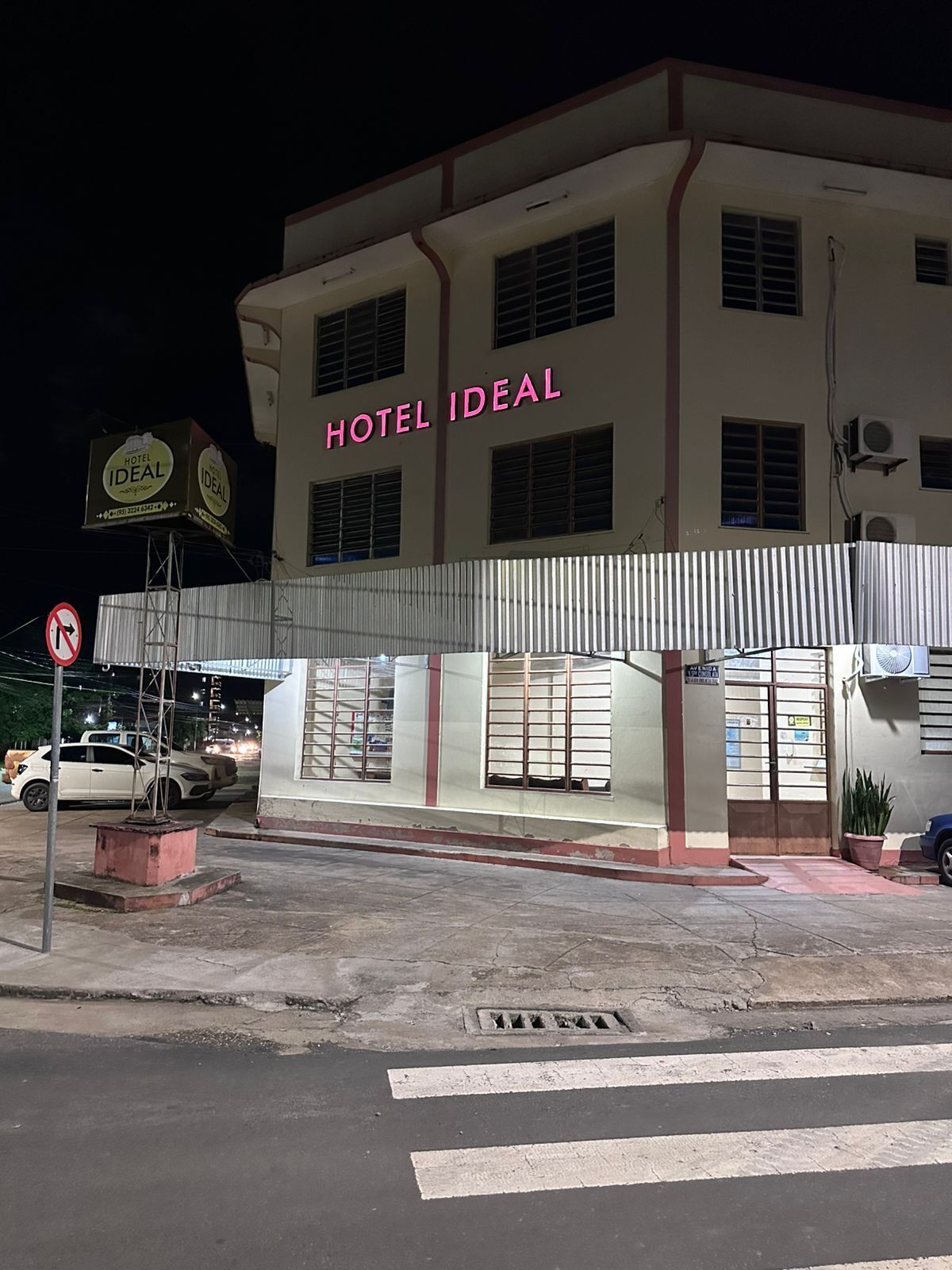 A building with a sign reading 'HOTEL IDEAL' and a no parking sign.