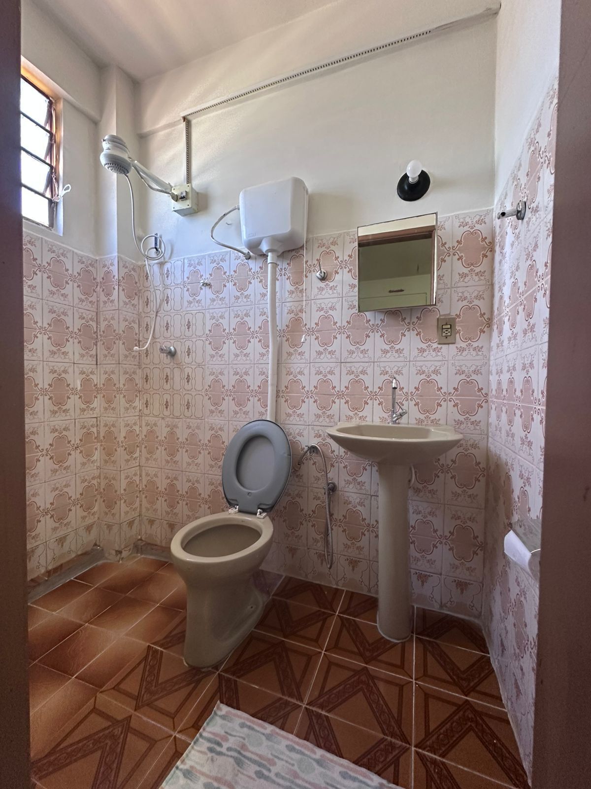 Un bagno con toilette, bidet, lavandino e uno specchio.