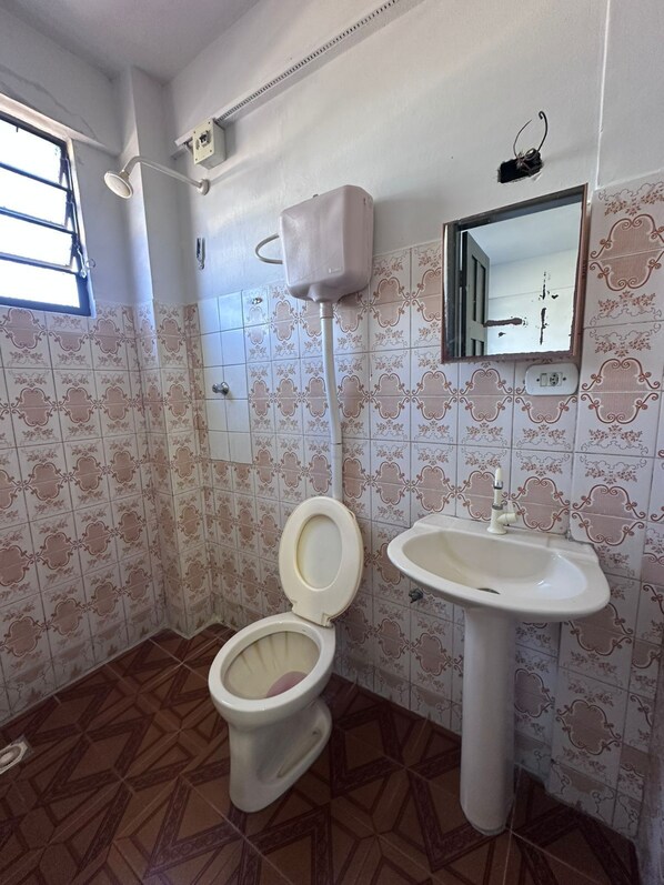 Un baño con inodoro, lavabo y ducha.