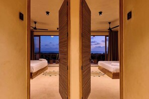 A mirrored room with two beds, a ceiling fan, and a view of the sky. - Ocean View Retreat w/ Rooftop Yoga & Pool (Puerto Escondido)