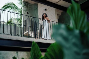 A balcony with metal railings, a concrete wall, and a palm tree in the background. - Chic Studio with Pool, Steps to La Punta Beach (Puerto Escondido)