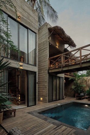 A modern house with a pool, a wooden deck, and a thatched-roof structure. - Contemporary Villa Near The Beach (Puerto Escondido)