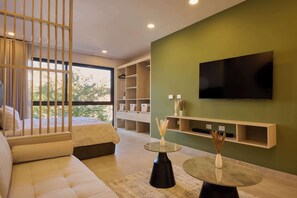 Un salon moderne comprenant un canapé, une table basse, un téléviseur et des étagères intégrées.