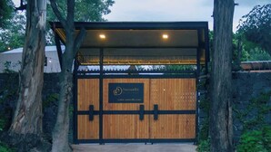 A wooden gate with a sign for 'Sannuchi' and a website address. - Casa Samadhi - Villa #5 Padme para dos (Atlixco)