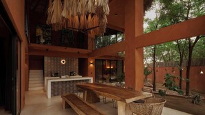 A spacious indoor area with a large wooden table, benches, and wicker chairs. - 200m to beach Casa Caimán w/ Private Pool & Tranquility (Puerto Escondido)
