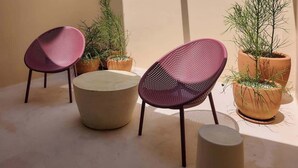 A small outdoor seating area with two chairs and a table, surrounded by potted plants. - Stylish King Apartment in Oaxaca's Reforma District (Oaxaca de Juárez)