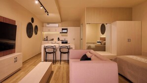 A modern, compact living space with a kitchenette, a sofa, a dining area, and a bed. - Stylish King Apartment in Oaxaca's Reforma District (Oaxaca de Juárez)