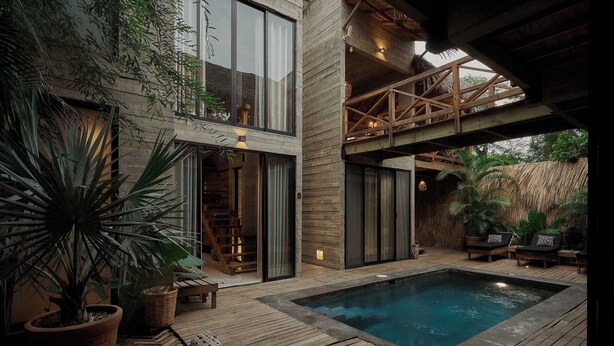 Un espace piscine extérieur moderne, doté d’une terrasse en bois, d’un jacuzzi et de plantes en pot.