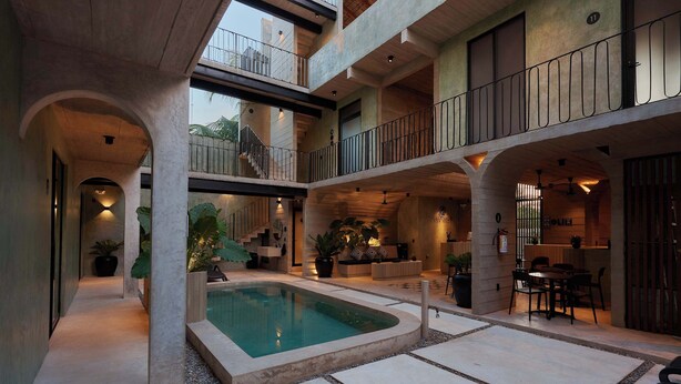 A multi-level building with a central courtyard, a swimming pool, and outdoor seating areas. - Stylish Apartment 2 Blocks from Punta Zicatela Beach (Puerto Escondido)