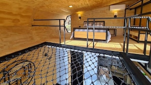 A wooden interior with a netted pool area, a bed with a headboard, and a staircase. - Casa Samadhi - Villa #1 Namaha para dos + Tina (Atlixco)