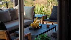 Un espace extérieur moderne aménagé avec un canapé, des fauteuils et une table basse.