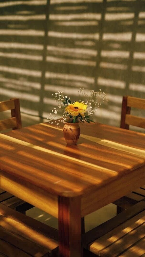 Une table en bois avec un vase de fleurs.