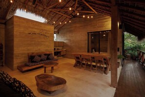 Un interior de madera con un sofá, una mesa de comedor y sillas.