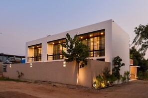 A modern two-story building with large windows and a flat roof. - Oceanview King Suite w/ Soaking Tub & Rooftop Terrace (Puerto Escondido)