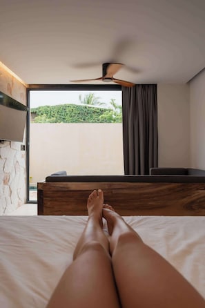 A bedroom with a bed, a ceiling fan, a window with curtains, and a view of greenery outside. - Stylish Villa w/ Private Pool Near Beach (Puerto Escondido)