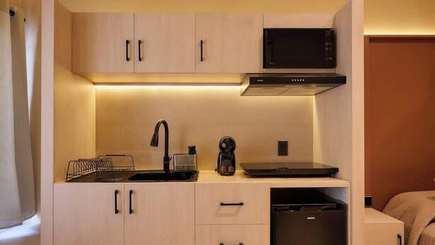 A compact kitchenette with a microwave, coffee maker, and dishwasher. - Stylish King Apartment in Oaxaca's Reforma District (Oaxaca de Juárez)