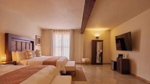Une chambre d’hôtel avec deux lits, une télévision, un bureau et un miroir.