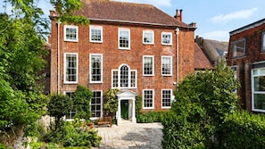 A traditional brick building with multiple windows and a central entrance with a white door. - Large celebration Town House in Chichester City Centre. Great for groups/families! (Chichester)