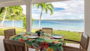 A table set for dining with a view of the ocean and palm trees. - PARADISE II (Bora Bora)