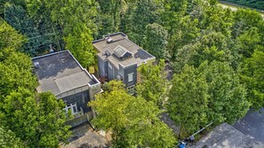 An aerial view of a residential area with two houses surrounded by dense greenery. - The Steele Mill + Loft (Indianapolis)