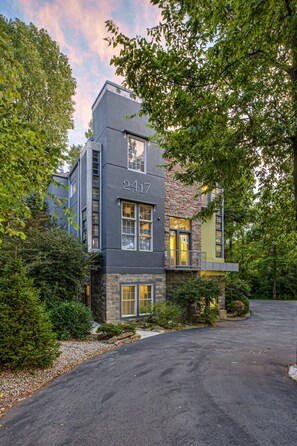 A modern two-story building with a stone facade and a large window. - The Steele Mill + Loft (Indianapolis)