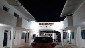 A building with a sign reading 'MEDITERRANEO' and a car parked in front.