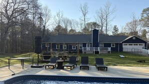 Um imóvel residencial com piscina, área de estar externa e garagem.