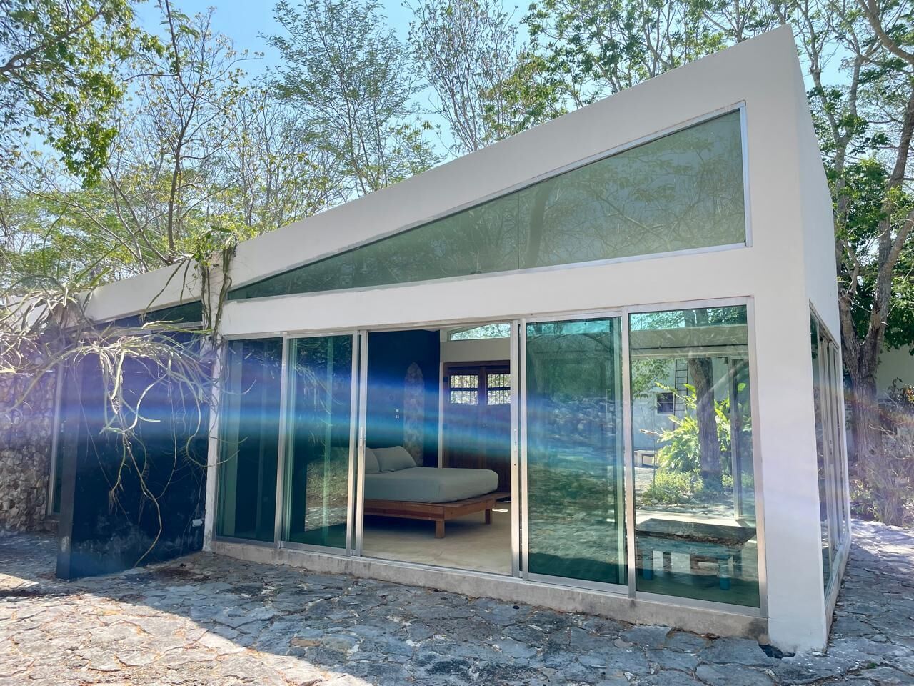 Una habitación moderna, con paredes de vidrio y una cama, que ofrece vistas del paisaje circundante.