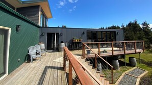 A modern house with a deck, a staircase, and a large window. - Mollusk Alaska Retreat, Private Coastal Escape in Homer, AK (Homer)