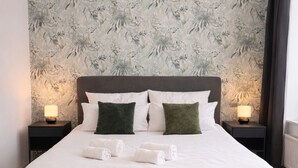A modern bedroom with a large bed, two bedside tables, and a patterned wallpaper. - MIILOX Apartments Chemnitz (Chemnitz)