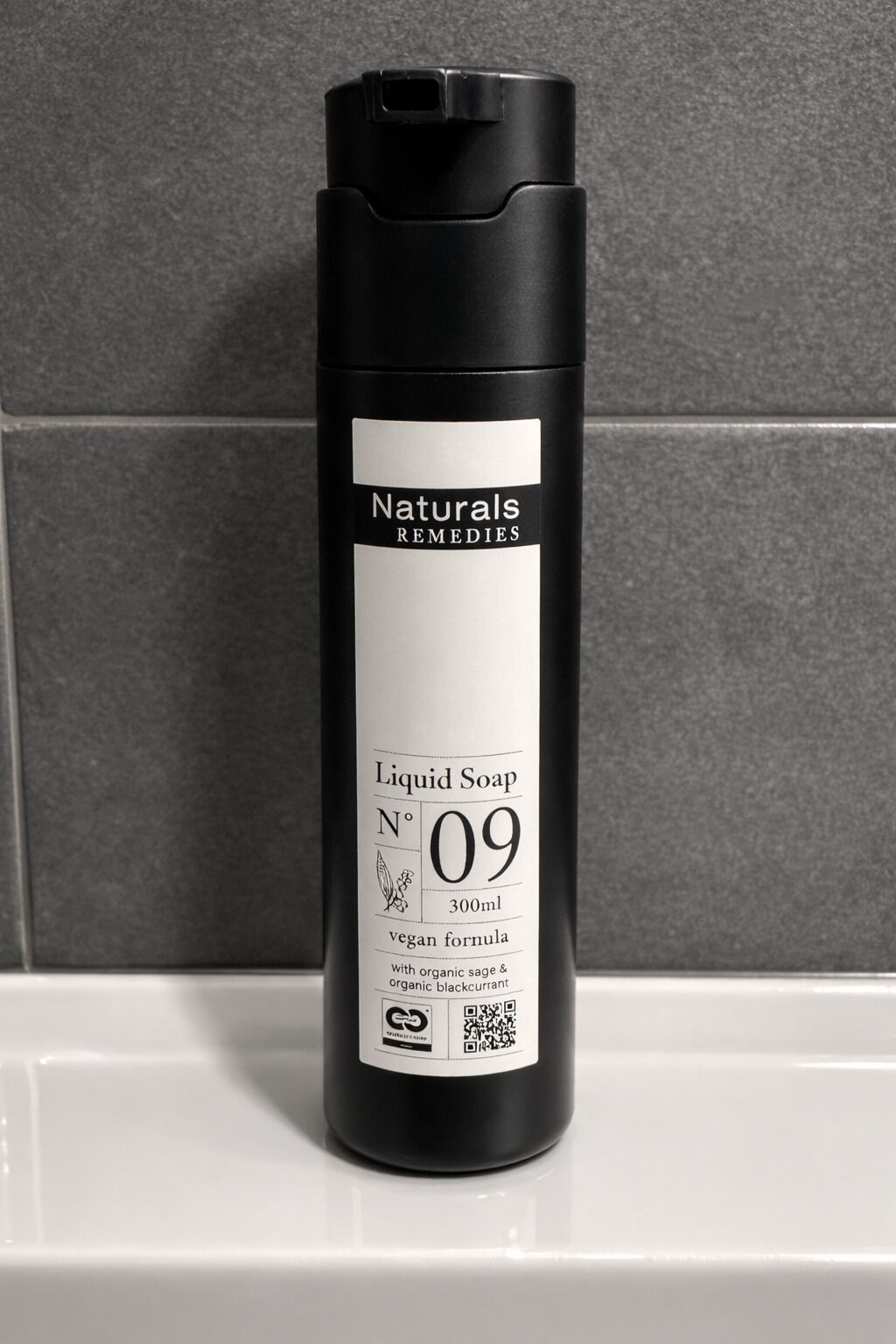 A black bottle of Naturals Remedies Liquid Soap No 09, 300ml, with a vegan formula, on a white surface.