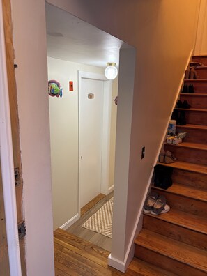 Ein Flur, der zu einer Tür mit der Aufschrift 'Laundry Room' führt, mit einer Leuchte darüber.