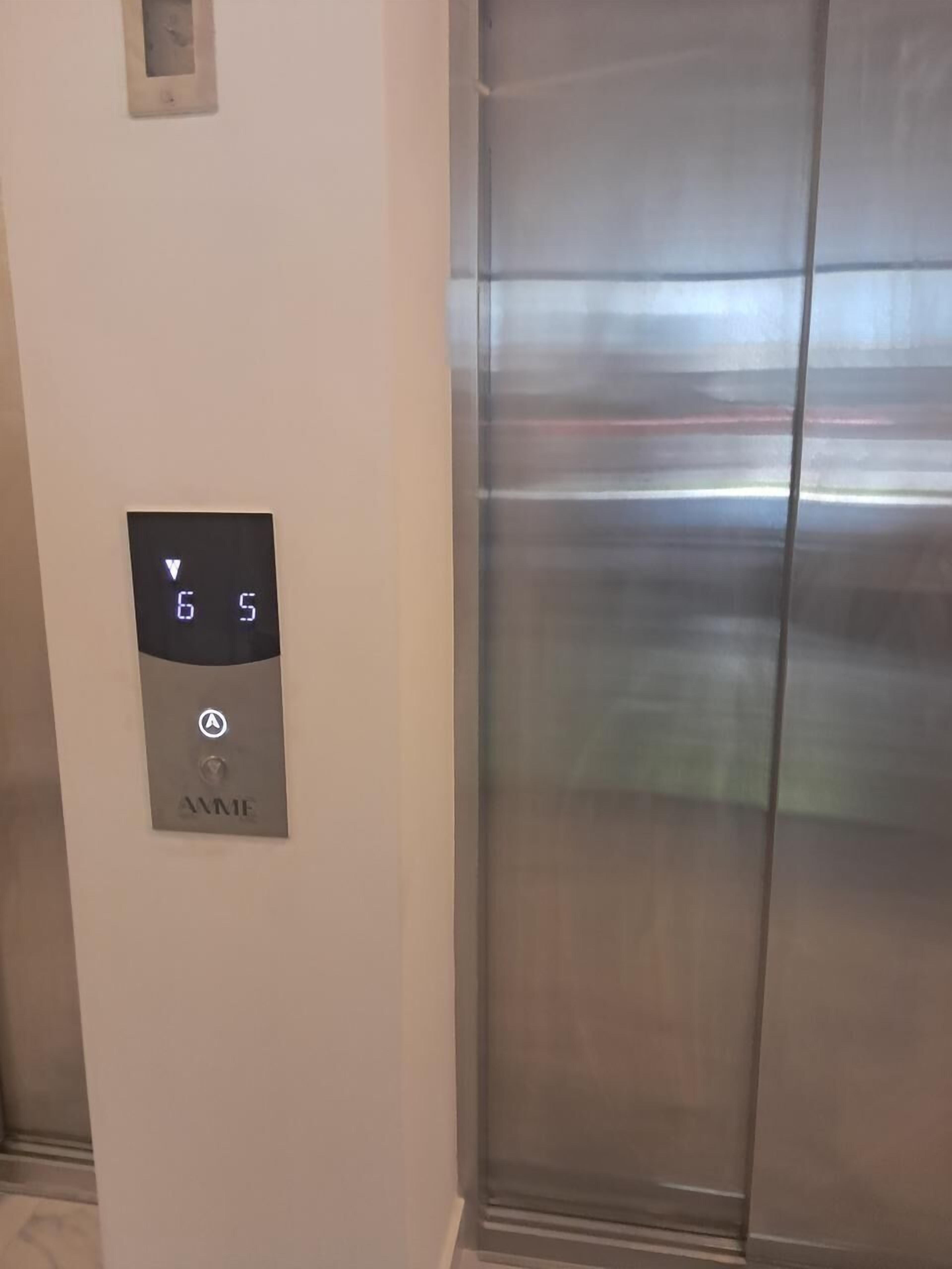 An elevator with a digital display showing the numbers 6 and 5, and a door with a metallic finish.