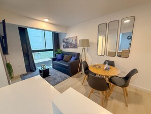 A modern living room with a sofa, a dining table with chairs, a floor lamp, and a large window. - San Isidro financial district stay (404) (Lima)