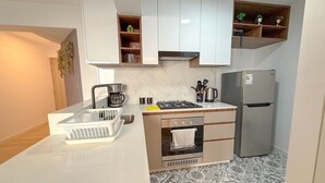 A modern kitchen with a built-in oven, a stainless steel refrigerator, and a coffee maker. - San Isidro financial district stay (404) (Lima)