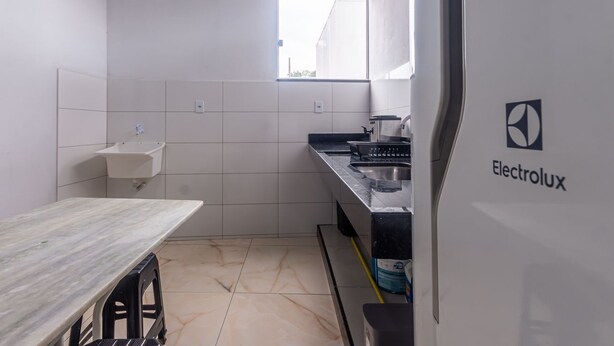 A compact kitchen with a sink, countertop, and a window. - Apartamento Para 6 h Spedes com Wi-fi e Garagem (Para de Minas)