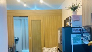 Ein kompakter Wohnbereich mit Küchenzeile, einem Bett, einer Essecke und einem Badezimmer.