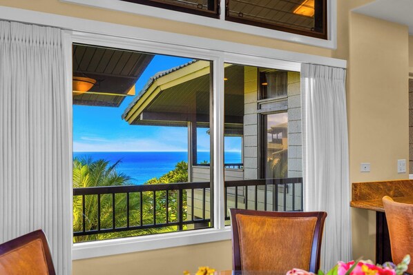 A room with a large window overlooking a balcony with a view of the ocean. - Kapalua Ridge | Ocean View 6 BR, Sleeps 22 | Car Incl. w/ 6+ Nights | KRV ML-3699 by KBM (Lahaina)