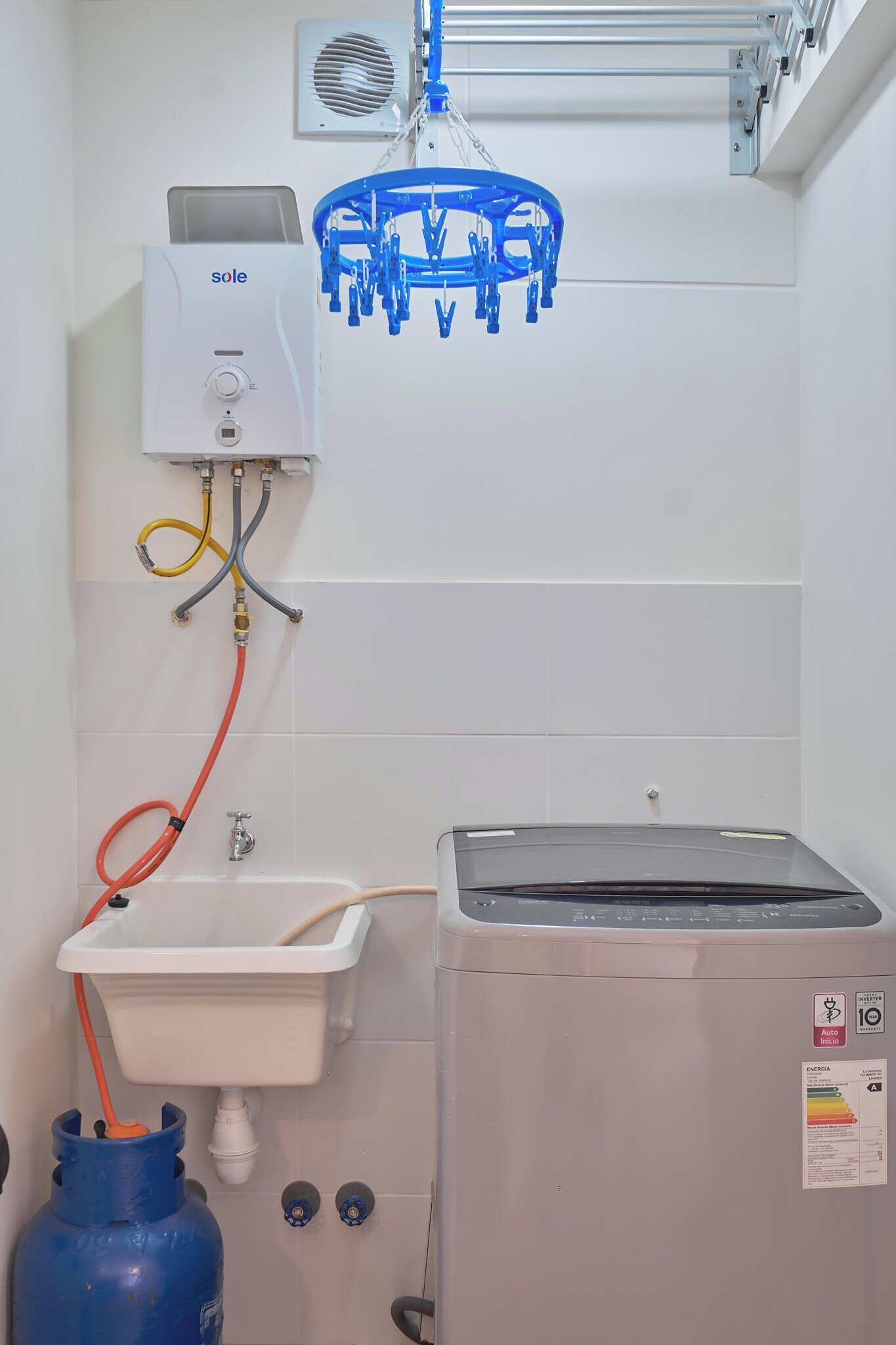 Un bagno con uno scaldabagno, un lavandino e una bombola di gas.