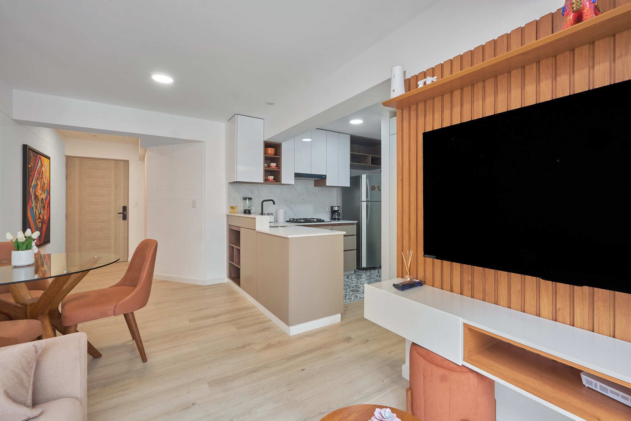 Una cocina moderna con armarios blancos, una isla central y un refrigerador integrado.