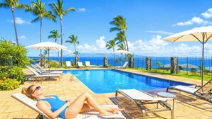 Zona piscina con lettini, ombrelloni e vista sull'oceano.