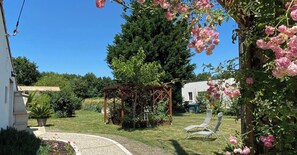 A garden with a pergola, a lawn, and a white building in the background. - Fleurs de Mer - GRAYAN AND THE HOPITAL (GRAYAN ET L'HOPITAL)